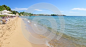 Pefkos beach with holiday-makers, sun beds and umbrellas in village of Pefkos - PANORAMA Rhodes, Greece