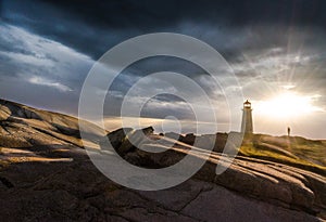 Peggy`s Cove Lighthouse at sunset with storm clouds