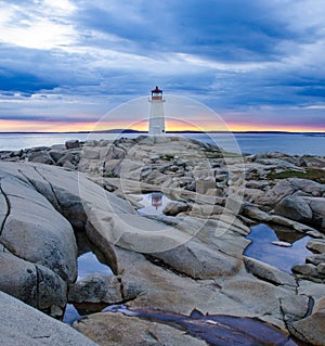 Peggy`s Cove Lighthouse at sunset with storm clouds