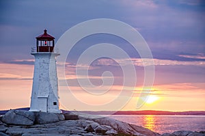 Peggy`s Cove Lighthouse at sunset with storm clouds photo