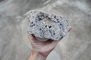 Pegmatite granite rock specimen in a hand.