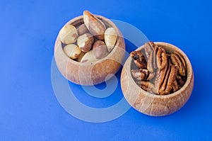 Pekan and brazil nuts on blue background. Healthy food photo