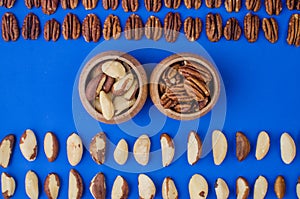 Pekan and brazil nuts on blue background. Healthy food photo