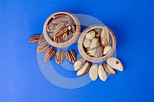 Pekan and brazil nuts on blue background. Healthy food photo