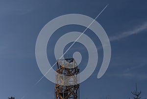 Pekelsky hill with observation tower and flying airplane and blue sky