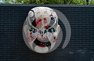 peking opera mask on brick wall background