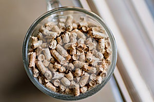 Pellet for stove or boiler in a glass, compressed wood granule photo