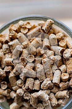 Pellet for stove or boiler in a glass, compressed wood granule photo