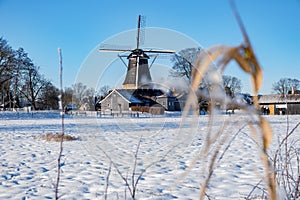 Pelmolen Ter Horst, Rijssen covered in snowy landscape in Overijssel Netherlands, historical wind mill during winter