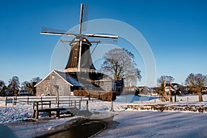 Pelmolen Ter Horst, Rijssen covered in snowy landscape in Overijssel Netherlands, historical wind mill during winter