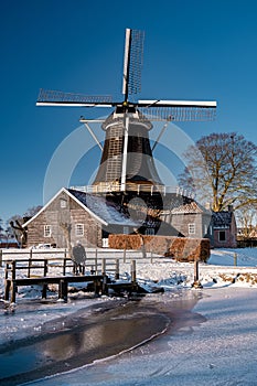 Pelmolen Ter Horst, Rijssen covered in snowy landscape in Overijssel Netherlands, historical wind mill during winter