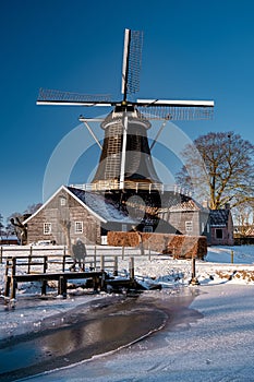 Pelmolen Ter Horst, Rijssen covered in snowy landscape in Overijssel Netherlands, historical wind mill during winter