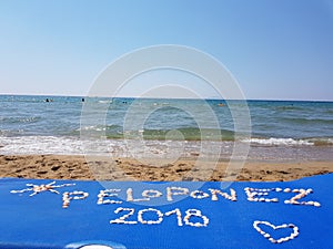 Peloponez 2018 text written with shells on the beach surrounded by the sea in Greece