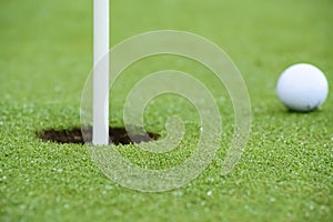 Pelota de golf apunto de entrar en el hoyo photo