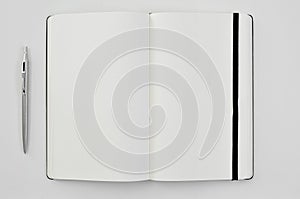 Pen and blank notepad on a white table