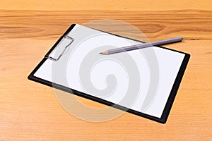 Pen on blank white document sheet on wood clipboard on white wood table top view space