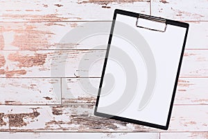 Pen on blank white document sheet on wood clipboard on white wood table top view space