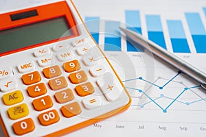Pen and calculator on chart or graph paper. Financial, account, statistics and business data concept