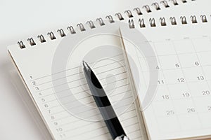 Pen with calendar and note pad with list of number for reminder, task and event planning concept