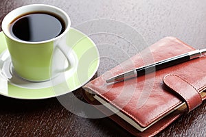 Pen on diary and coffee mug