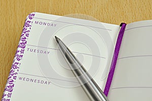 Pen on diary with names of week days