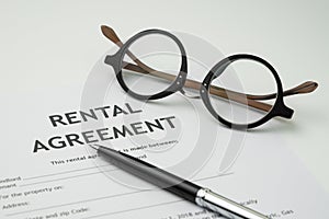 Pen and eyeglasses on rental agreement printed document, ready t