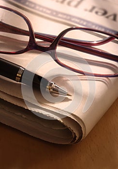 Pen and Glasses on Newspaper