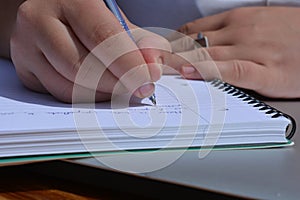 Pen in hand, woman writing in a spiral bound notebook