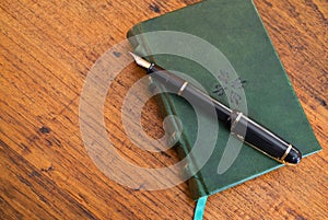 Pen and journal on wooden desk