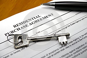 Pen and key on property purchase agreement