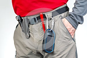 Pen, knife and flashlight with clips on the waistband of trekking pants. EDC items