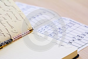 Pen and laptop in English in the school desk.