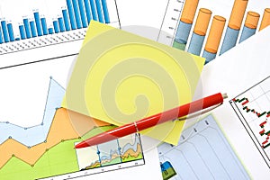 Pen and memo over charts