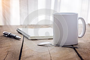 Pen and notebook with coffee cup on wooden