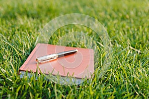 Pen and Notebook on Grass