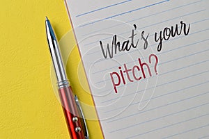 Pen and notebook with question WHAT`S YOUR PITCH