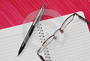 Pen, notebook and spectacles