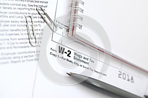 The pen and notebook on the tax form W-2 Wage and Tax Statement.