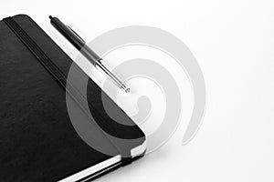 Pen an notepad isolated on a white canvas background with selective focusing on pen.
