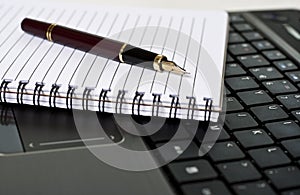 Pen, notepad and laptop on the desk