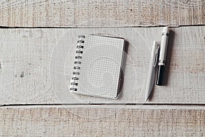 Pen and notepad on office wooden table