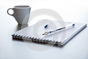 Pen and notepad on steel table.