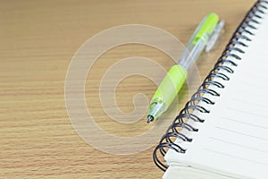 Pen and Notepad on the wooden desk background