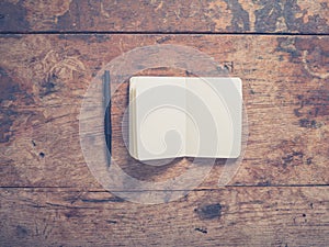 Pen and notepad on wooden table