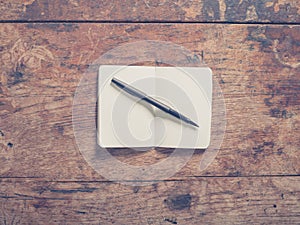 Pen and notepad on wooden table