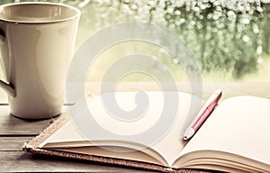 Pen on open notebook and coffee cup