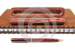 Pen in an opened wooden case on notebook
