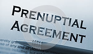 A pen on paper with words prenuptial agreement. Marriage contract concept