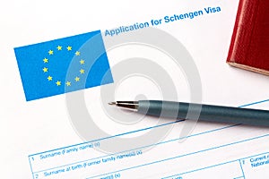 Pen and passport on blank European Union Schengen visa application form. Tourism and travel in Europe concept