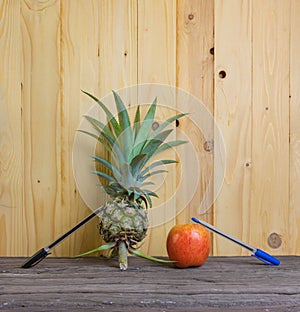 Pen-Pineapple-Apple-Pen on wooden background.